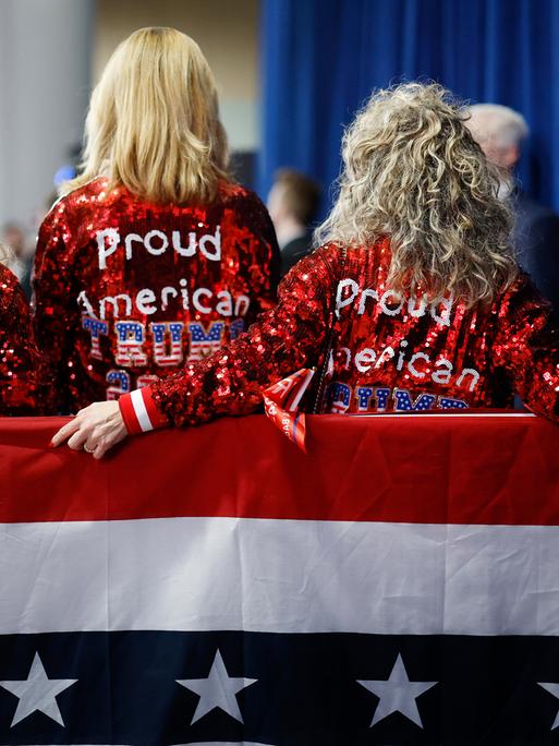 Anhängerinnen des ehemaligen US-Präsidenten Donald Trump in Iowa. Sie tragen glitzernde "Proud American" Jacken.