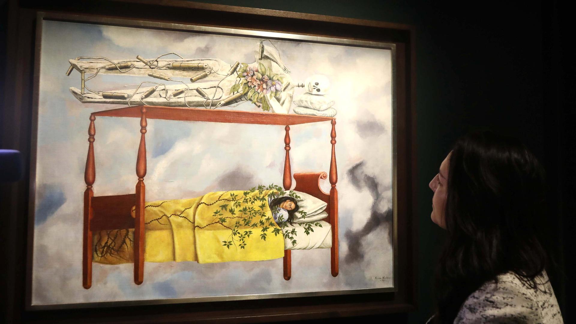 Eine Frau schlafend in einem Himmelbett, darauf liegt ein riesiges Skelett, dessen Beine mit Dynamit umwickelt sind