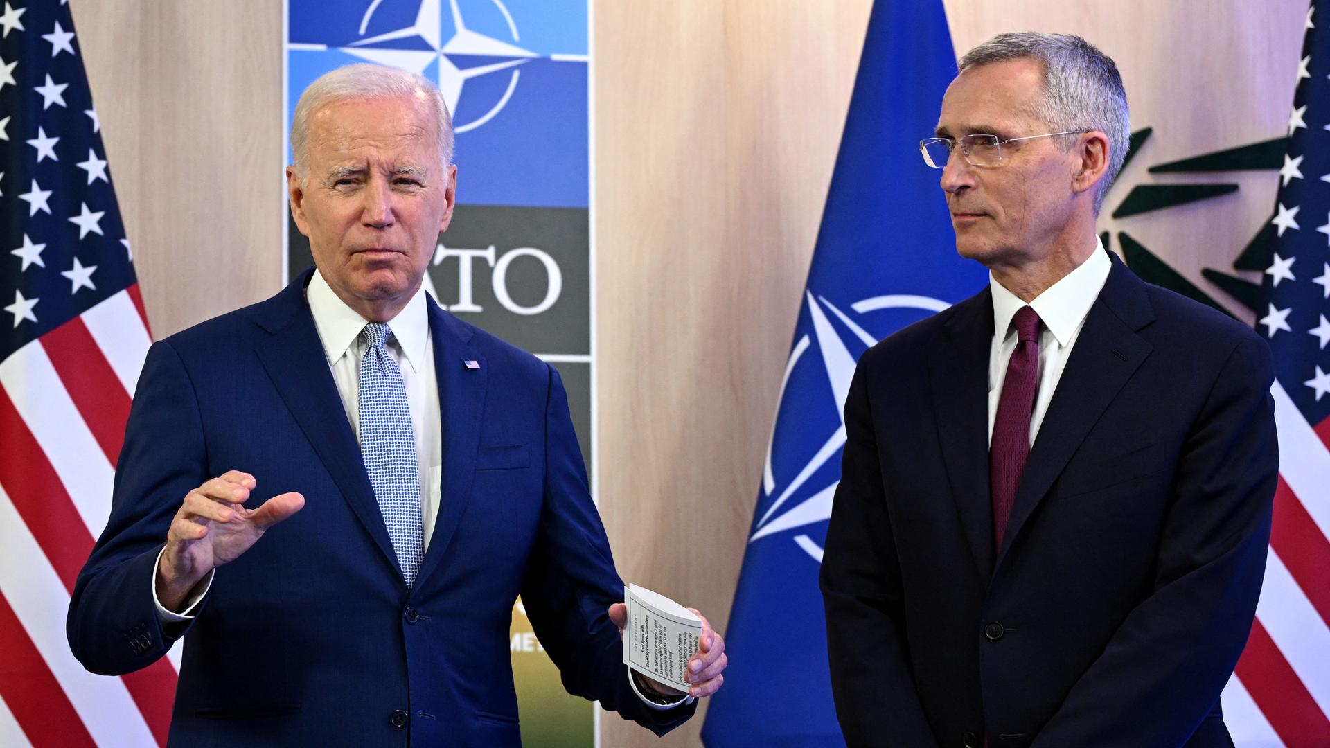 NATO-Generalsekretär Jens Stoltenberg (re) und US-Präsident Biden auf dem Gipfel in Litauen, vor den Flaggen der USA und der NATO stehend, 11.07.2023