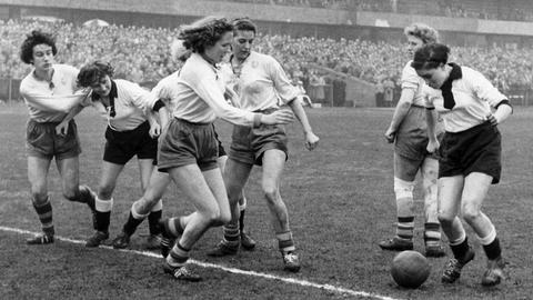 Die deutschen Frauen (in schwarzen Hosen) in einer Spielszene vor dem niederländischen Tor. Historisches Schwarzweißfoto.