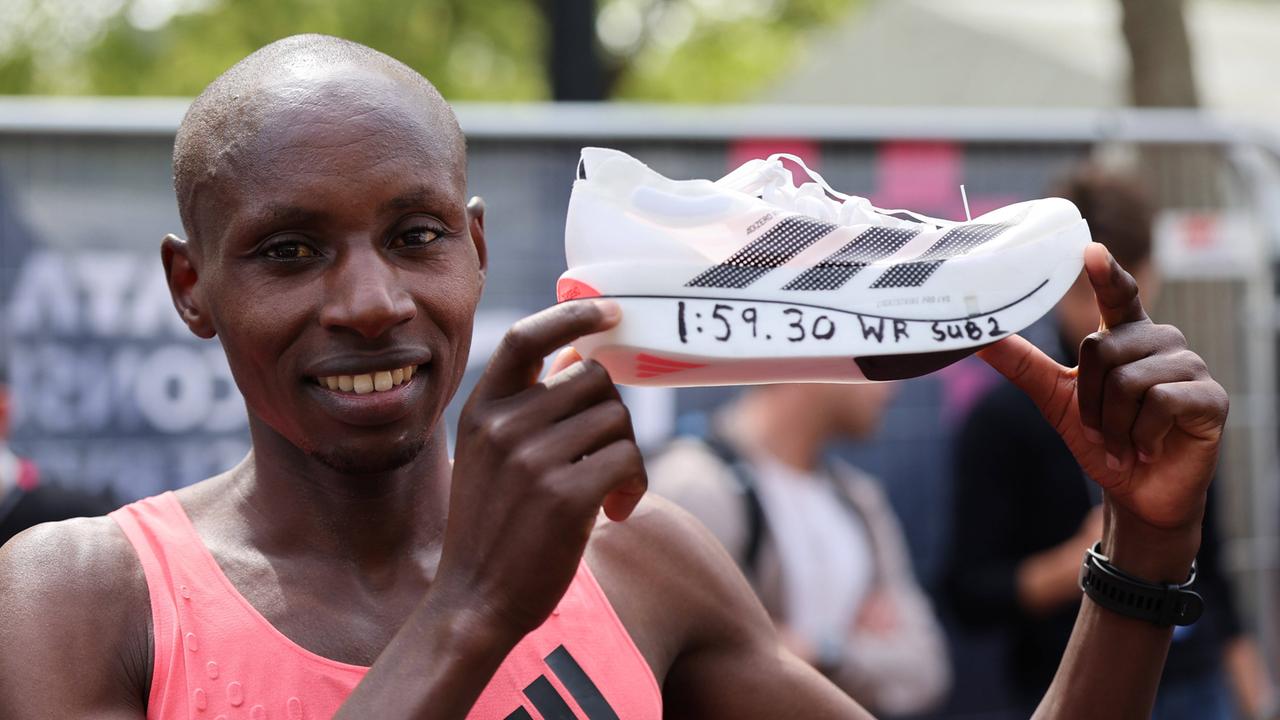 Sabastian Sawe hält seinen Sportschuh mit dem Marathon-Rekordwert in der Hand.