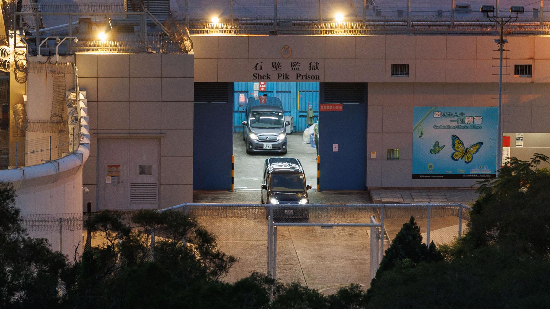 Zwei Autos verlassen das Shek Pik Gefängnis in Hongkong. Zwei Autos verlassen das Shek Pik Gefängnis in Hongkong.