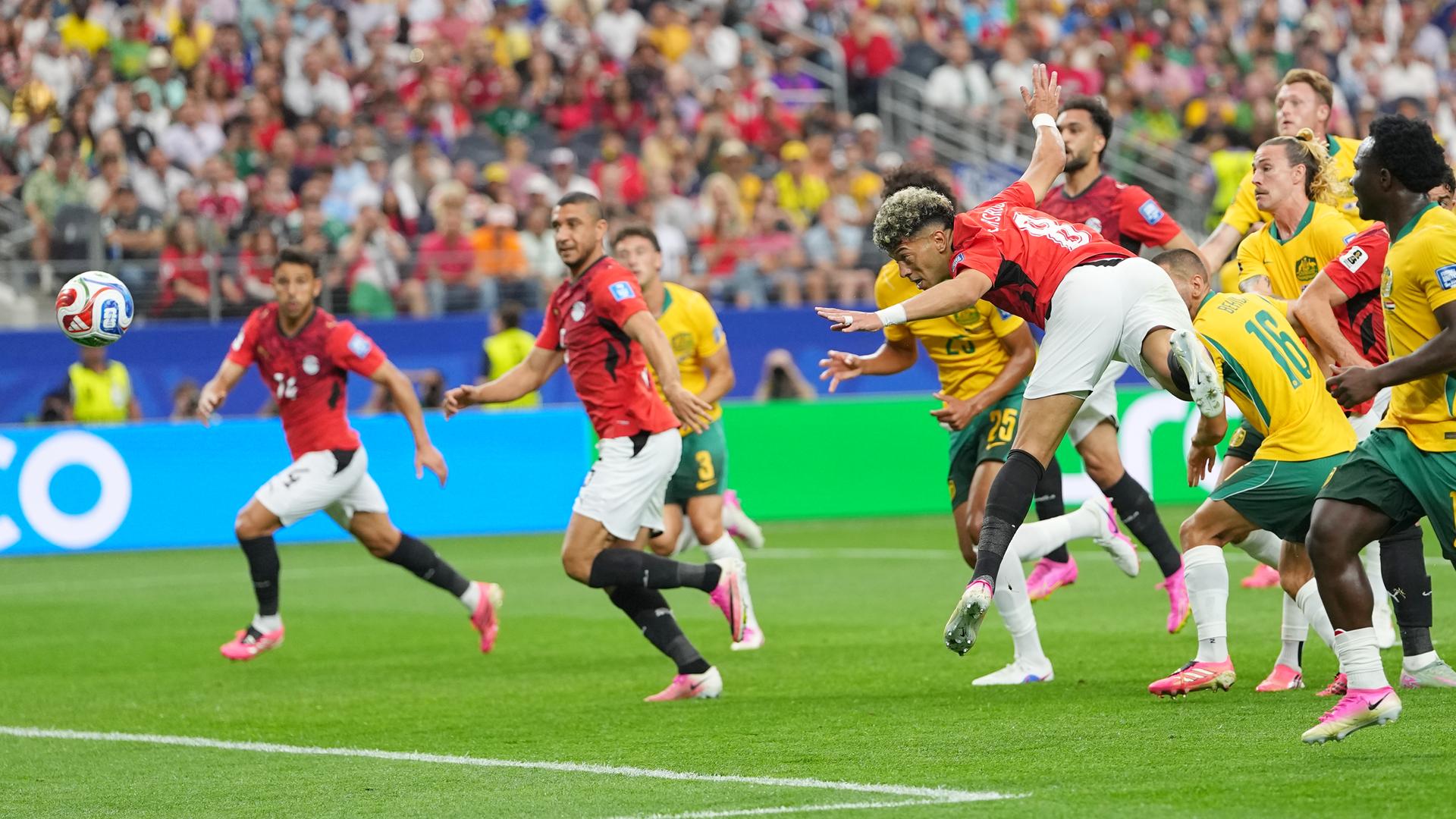 Zu sehen sind mehrere Fußballspieler der Mannschaften von Ägypten und Australien. Ein ägyptischer Spieler hat einen Kopfball ausgeführt. Zu sehen sind mehrere Fußballspieler der Mannschaften von Ägypten und Australien. Ein ägyptischer Spieler hat einen Kopfball ausgeführt.