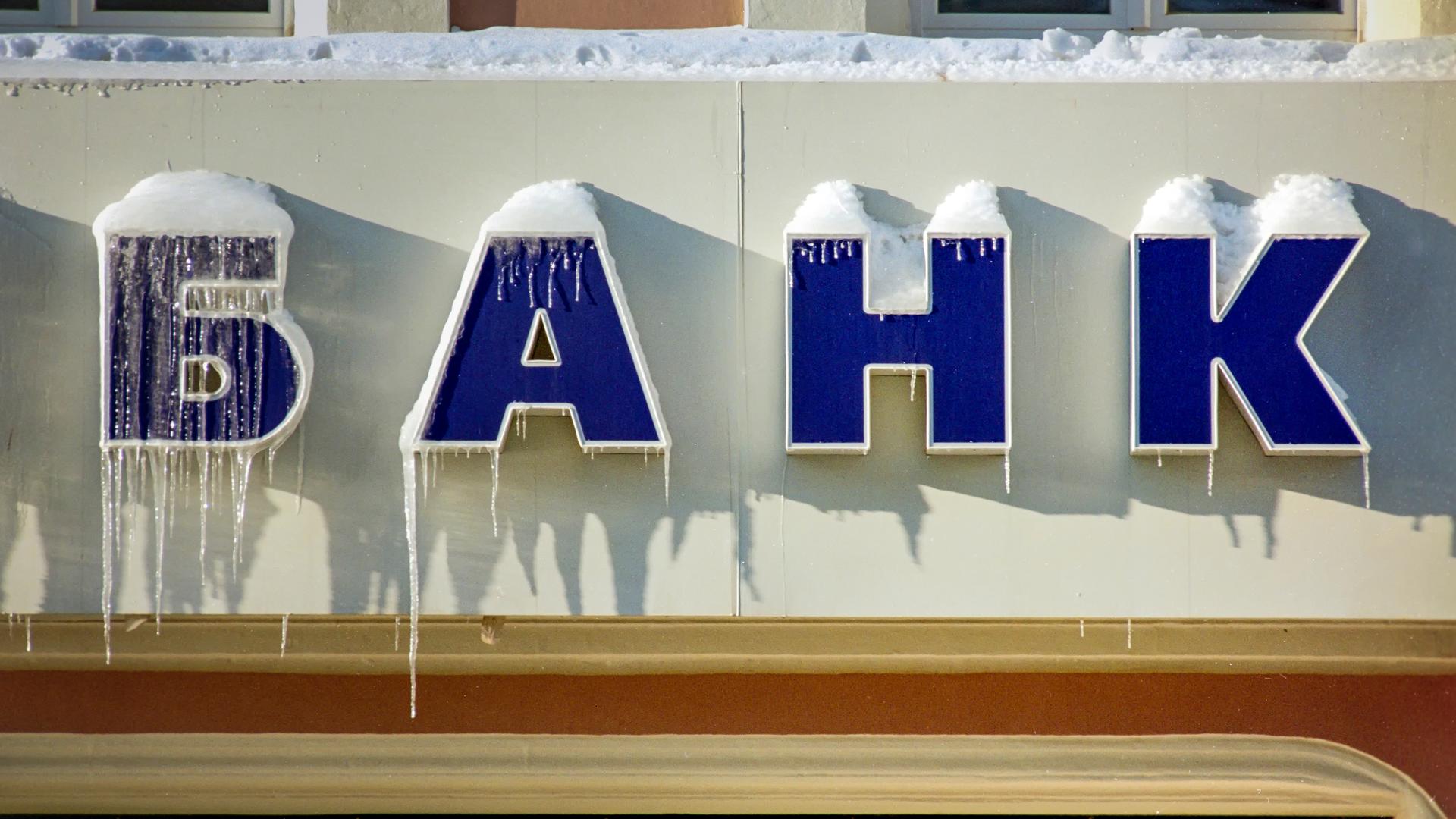 Das kyrillische Wort für "Bank" an einem Geldinstitut in Moskau. Der Schriftzug ist eingefroren und es hängen Eiszapfen hinunter.