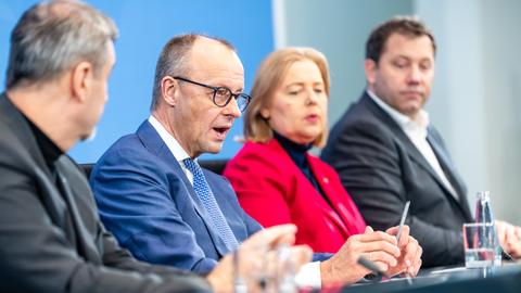 Bundeskanzler Merz (2.v.l., CDU), Finanzminister Klingbeil (r, SPD), Arbeitsministerin Bas (SPD) und der CSU-Vorsitzende Söder sitzen in der Pressekonferenz zu den Ergebnissen der Beratungen nach dem Koalitionsausschuss.