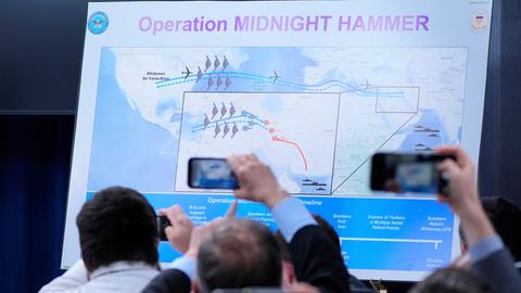 Reporter halten ihre Telefone hoch um Bilder von einer Karte zu machen, auf der abgebildet ist, wie die USA iranische Atomanlagen angegriffen haben

