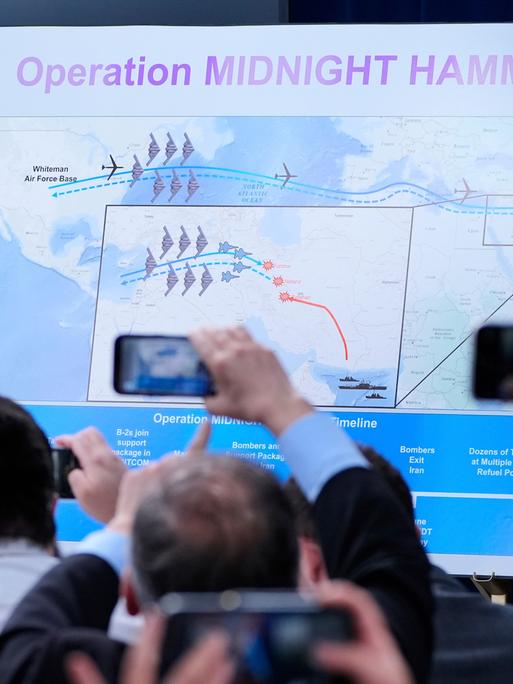Reporter halten ihre Telefone hoch um Bilder von einer Karte zu machen, auf der abgebildet ist, wie die USA iranische Atomanlagen angegriffen haben
