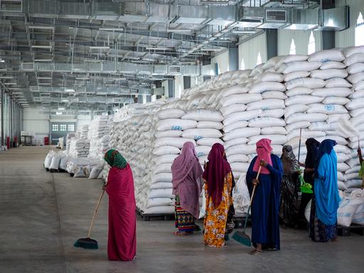 FILE - Workers clean the floor as sacks of food earmarked for the Tigray and Afar regions sits in piles in a warehouse of the World Food Programme (WFP) in Semera, the regional capital for the Afar region, in Ethiopia on Feb. 21, 2022. The aid agency Oxfam International warned Tuesday, March 22, 2022 that widespread hunger across East Africa could become "a catastrophe" without an injection of funds to the region's most vulnerable communities. (AP Photo, File)