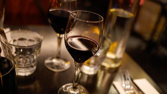 2 Gläser mit Rot-Wein stehen auf einem Tisch.