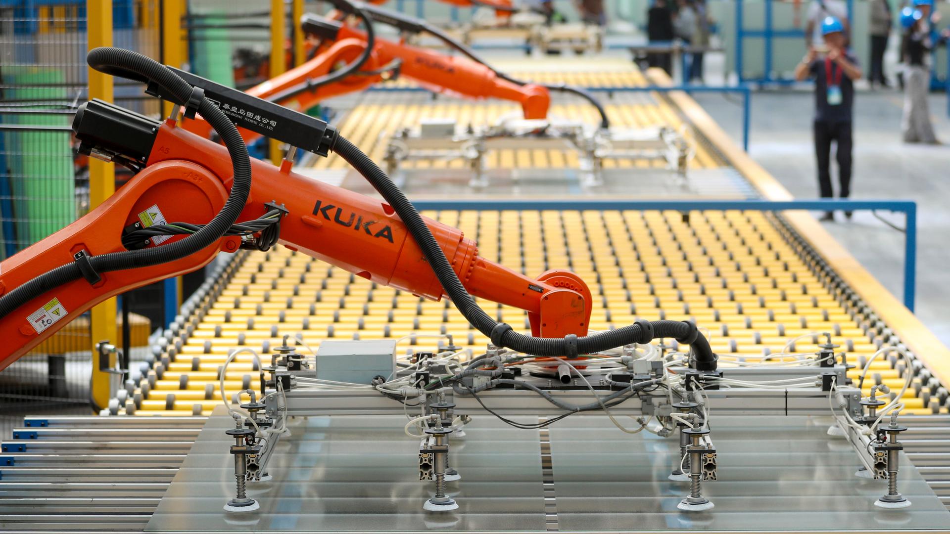 Orangefarbene Kuka-Roboter kommen in einer chinesischen Fabrik zum Einsatz.