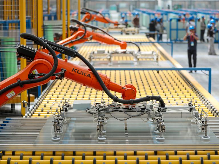 Orangefarbene Kuka-Roboter kommen in einer chinesischen Fabrik zum Einsatz. Orangefarbene Kuka-Roboter kommen in einer chinesischen Fabrik zum Einsatz.