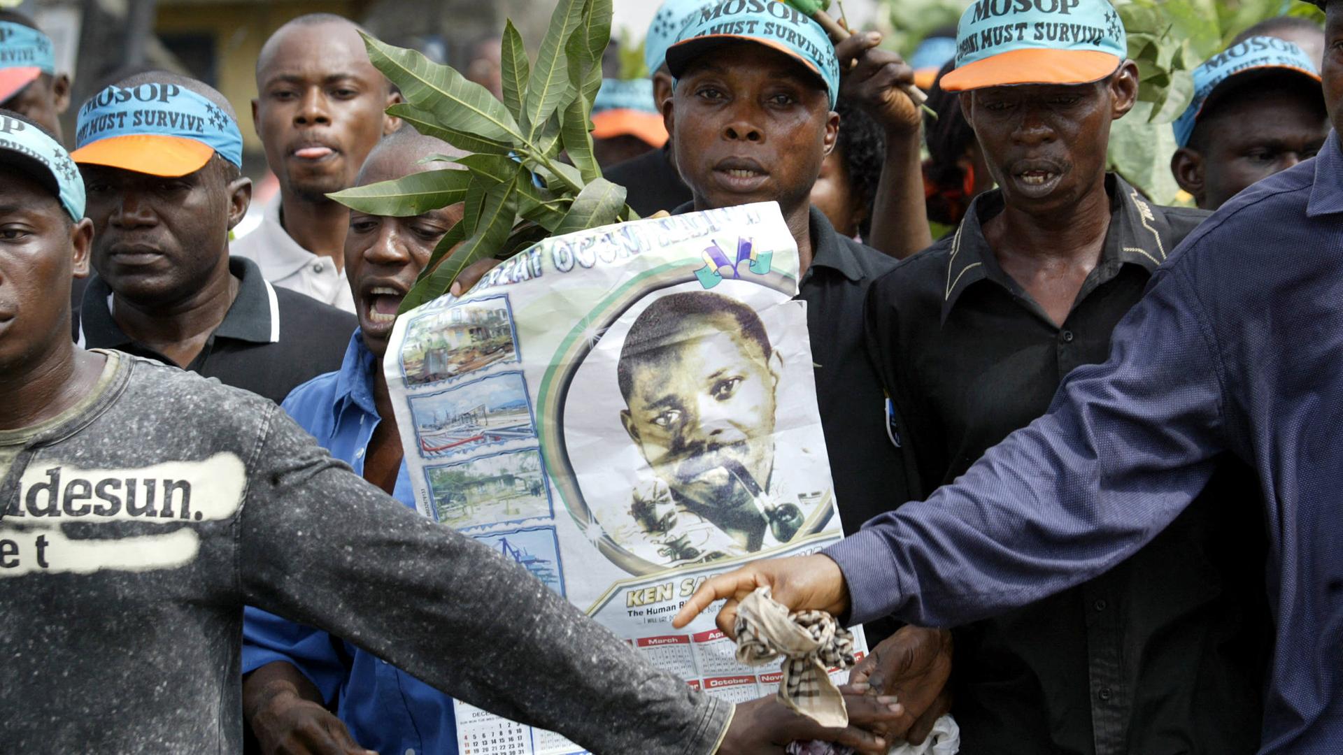 Indigene der Ogoni marschieren in Nigeria mit einem Plakat des Aktivisten Ken Saro-Wiwa.