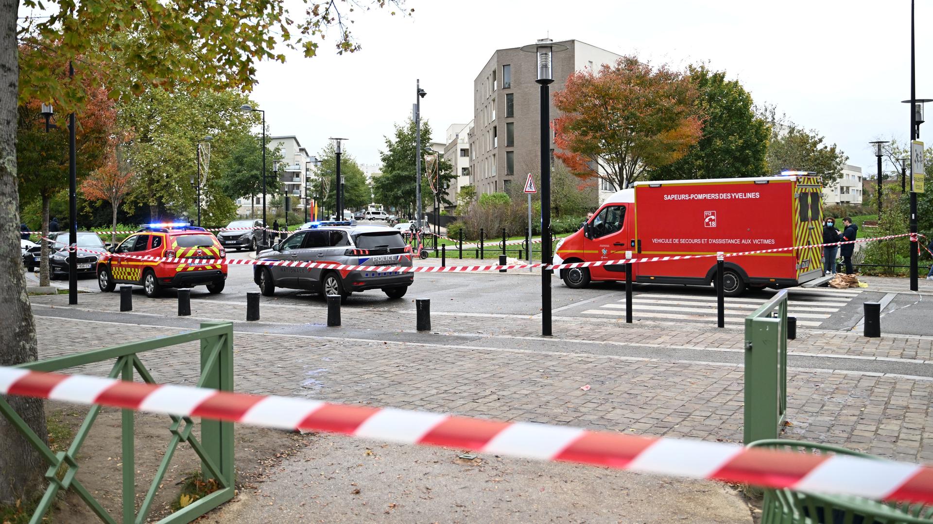 Zu sehen sind rot-weißes Absperrband und Einsatzfahrzeuge von Polizei und Sanitätern.