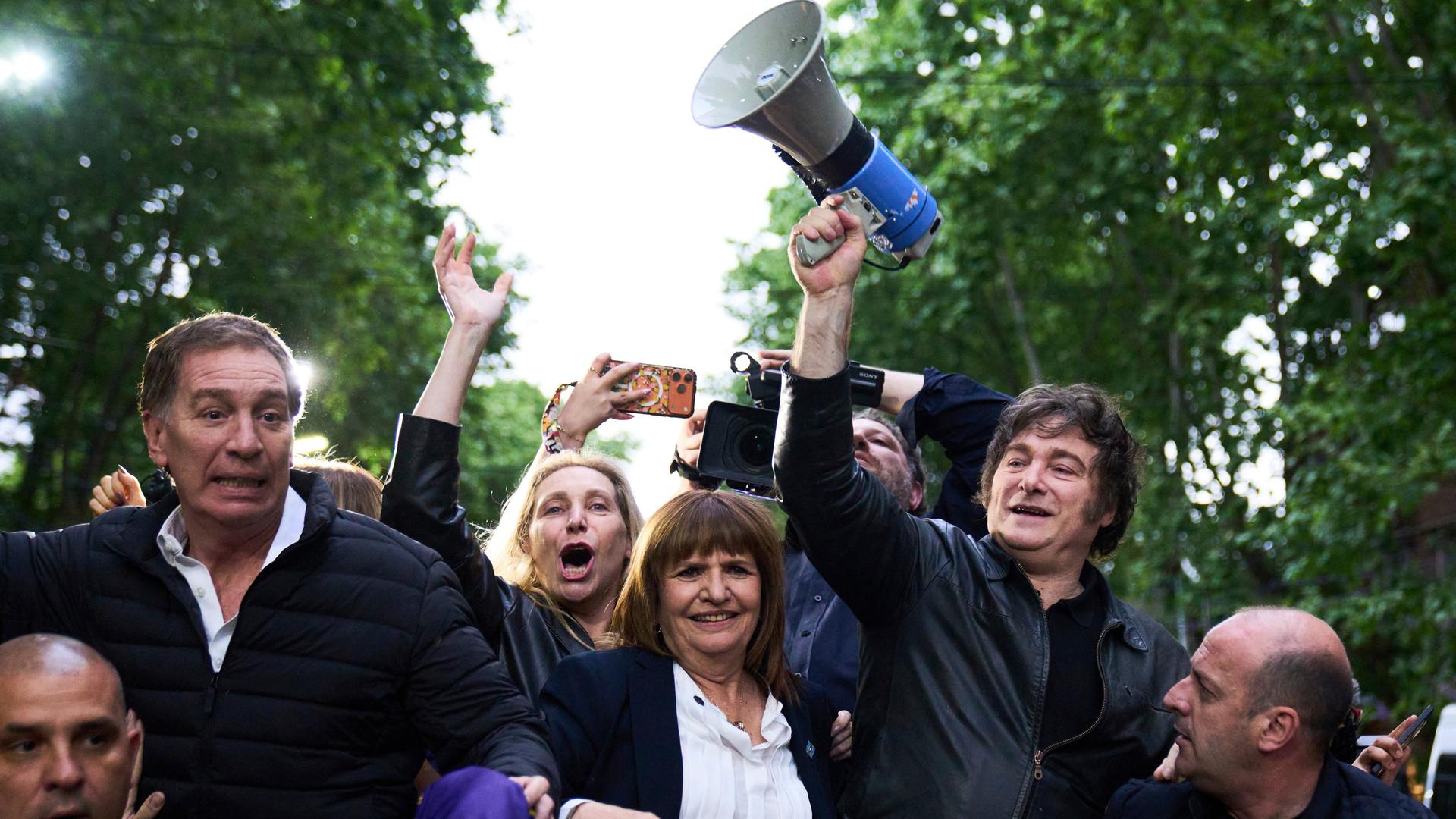 Argentinien, Buenos Aires: Argentiniens Präsident Javier Milei hält ein Megaphon in der Hand, während er eine Wahlkampfveranstaltung vor den Parlamentswahlen anführt. Er wird begleitet von dem Kandidaten Diego Santilli (2.v.l).