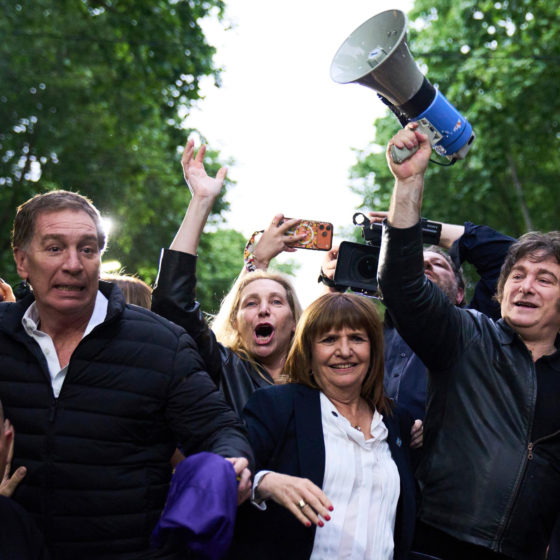Argentinien, Buenos Aires: Argentiniens Präsident Javier Milei hält ein Megaphon in der Hand, während er eine Wahlkampfveranstaltung vor den Parlamentswahlen anführt. Er wird begleitet von dem Kandidaten Diego Santilli (2.v.l).