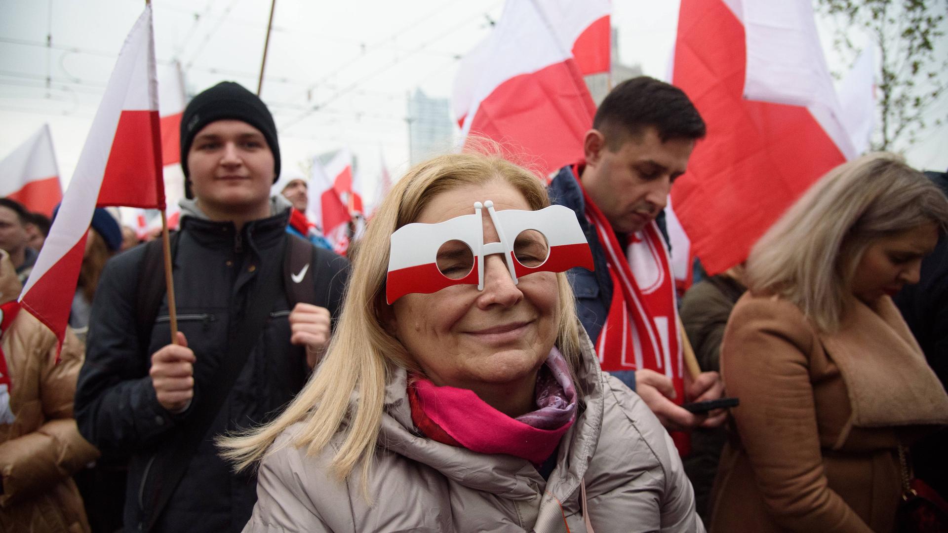 Eine Frau trägt eine Brille, die an polnische Flaggen erinnert, während sie am 11. November 2023 in Warschau, Polen, am 105. Jahrestag der Wiedererlangung der Unabhängigkeit Polens teilnimmt. 