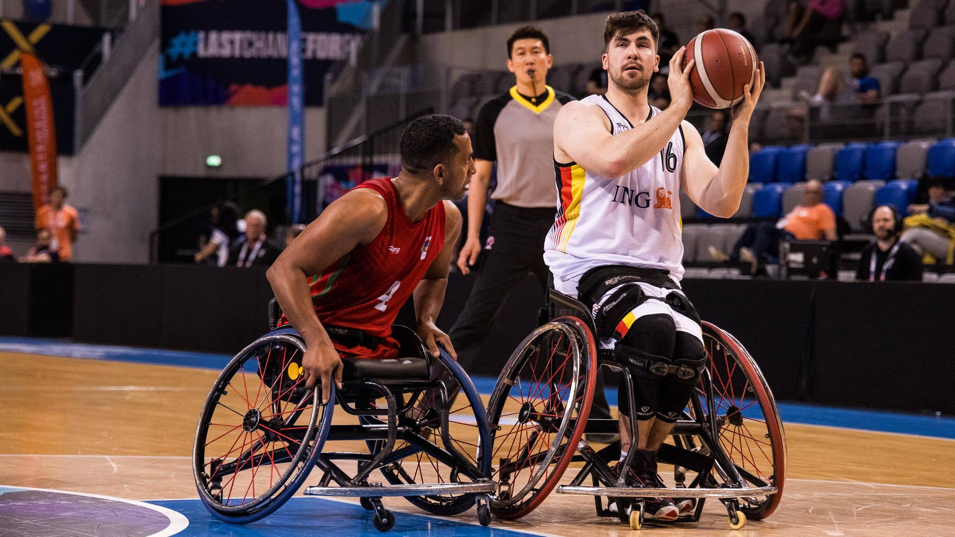 Rollstuhl-Basketballer Thomas Reier hat in einem Spiel gegen Marokko den Ball vor einem Spieler aus Marokko erobert und setzt zum Wurf an.