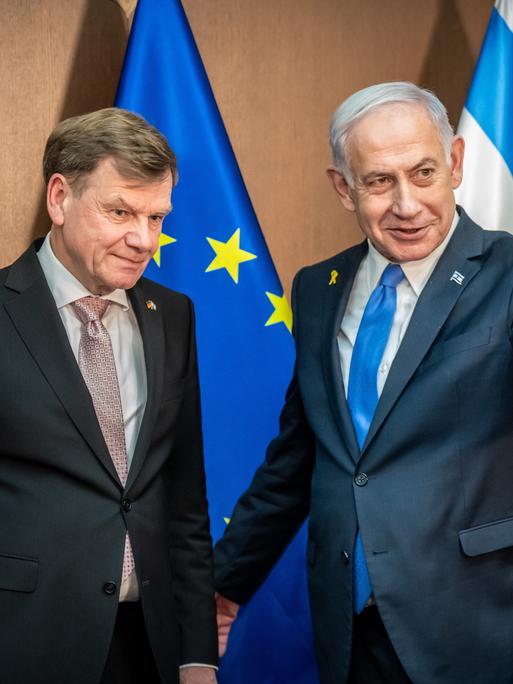 Johann Wadephul (l., CDU), deutscher Außenminister, steht neben Benjamin Netanjahu, Ministerpräsident von Israel, im Hintergrund die Flaggen Deutschlands, der EU und Israels.