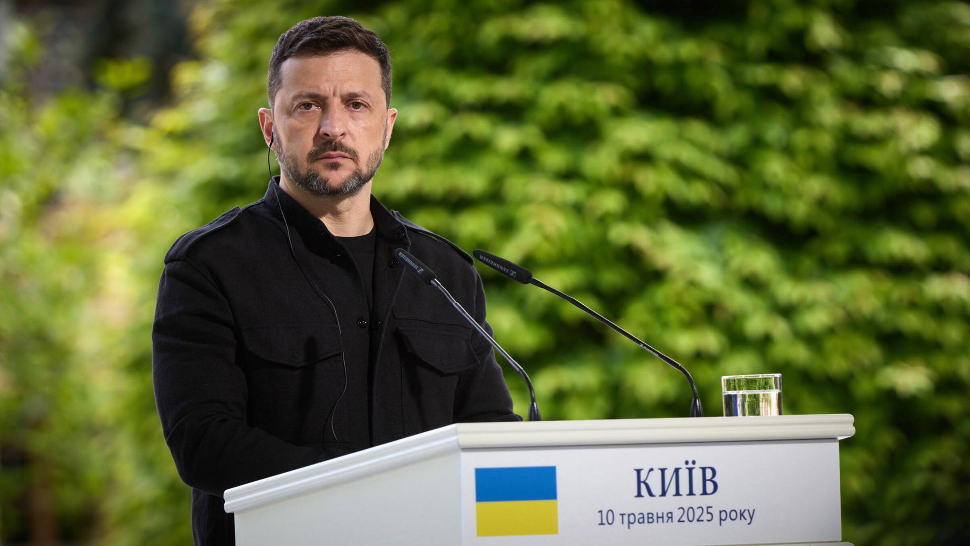 Ukraines Präsident Wolodymyr Selenskyj steht an einem Pult mit Mikrofon und blickt ernst in die Kamera. Ukraines Präsident Wolodymyr Selenskyj steht an einem Pult mit Mikrofon und blickt ernst in die Kamera.