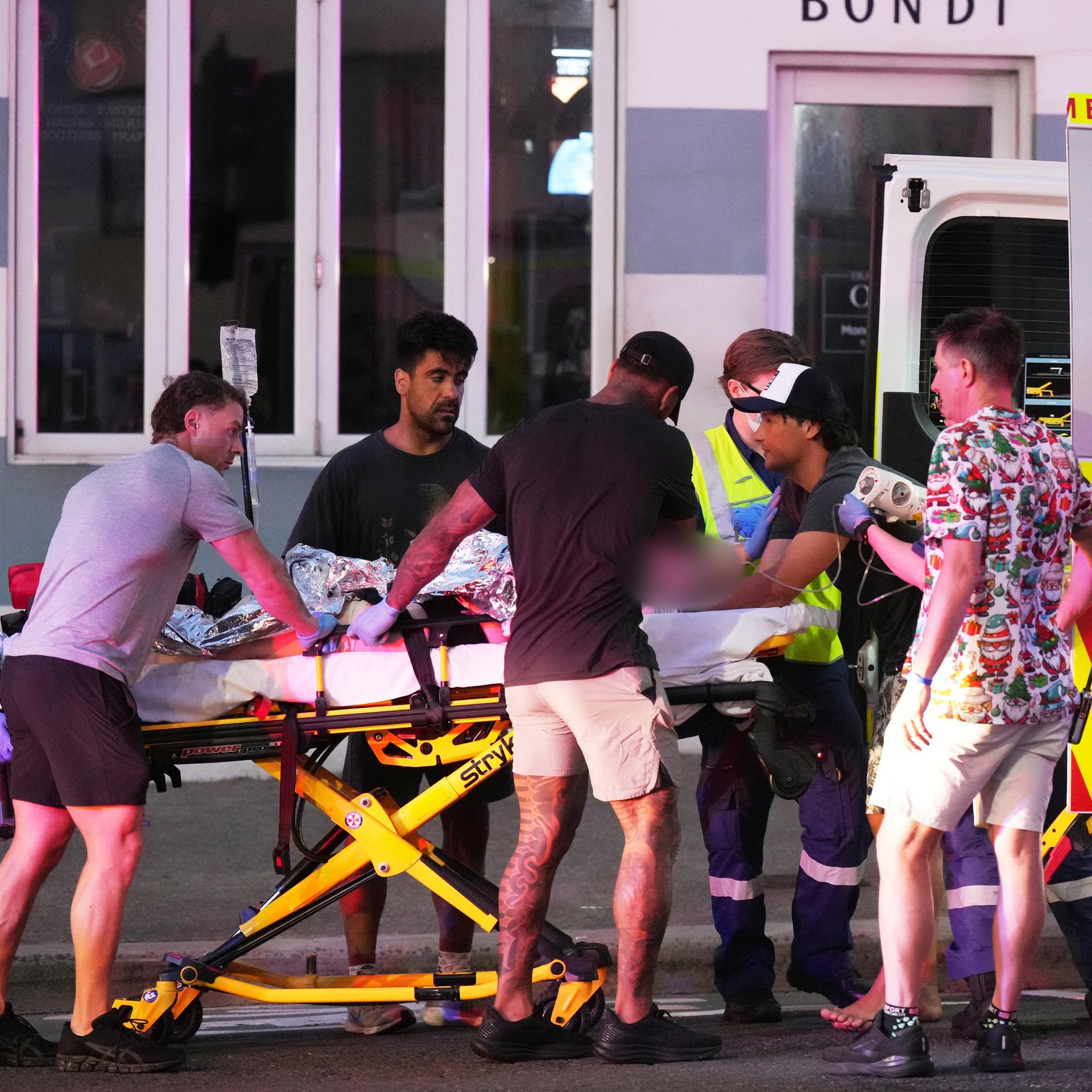 Rettungskräfte transportieren eine Person auf einer Trage. 