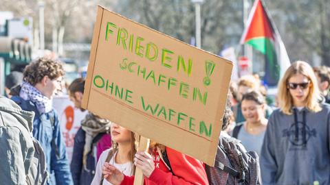 Rund 200 Schülerinnen und Schüler beteiligen sich an einem bundesweiten Schulstreik gegen Wehrdienst und mögliche Wiedereinführung der Wehrpflicht. Im Vordergrund ein Transparent mit der Aufschrift "Frieden schaffen ohne Waffen". 