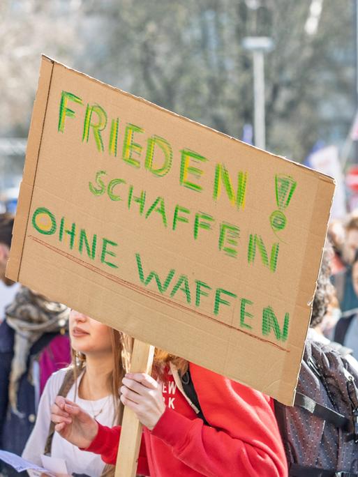 Rund 200 Schülerinnen und Schüler beteiligen sich an einem bundesweiten Schulstreik gegen Wehrdienst und mögliche Wiedereinführung der Wehrpflicht. Im Vordergrund ein Transparent mit der Aufschrift "Frieden schaffen ohne Waffen". 