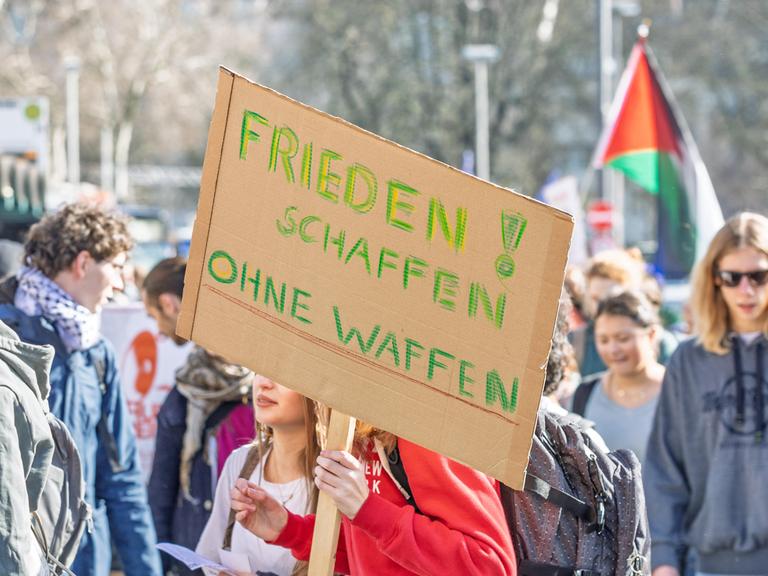 Rund 200 Schülerinnen und Schüler beteiligen sich an einem bundesweiten Schulstreik gegen Wehrdienst und mögliche Wiedereinführung der Wehrpflicht. Im Vordergrund ein Transparent mit der Aufschrift "Frieden schaffen ohne Waffen". 
