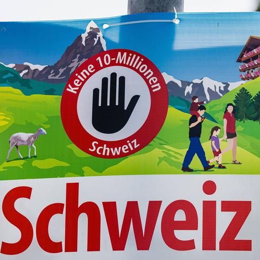 Ein Wahl-Plakat: Darauf ist zu lesen "Keine 10-Millionen Schweiz". Im Hintergrund sind Berge zu sehen und eine Familie.