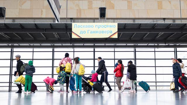 Geflüchtete aus der Ukraine laufen nach ihrer Ankunft durch die Eingangshalle vom Messebahnhof Laatzen.