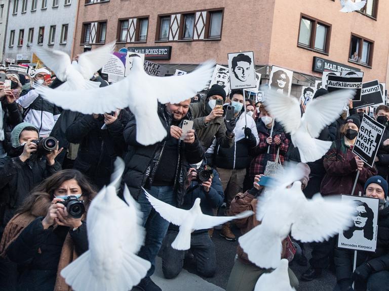 Weiße Tauben steigen in Erinnerung an die Opfer von Hanau bei einer Demonstration auf.