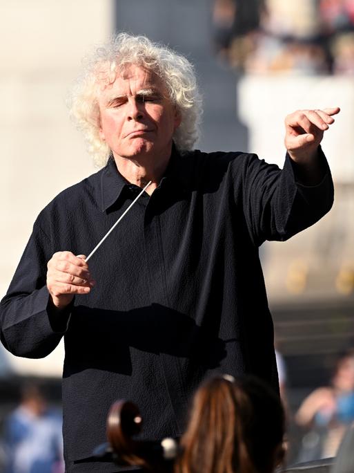 Simon Rattle dirigiert an einem sonnigen Tag Open Air das London Symphony Orchestra in London.