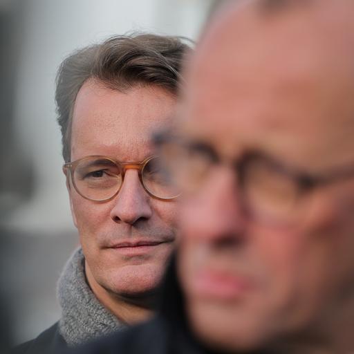 Hendrik Wüst (l, CDU), Ministerpräsident Nordrhein-Westfalen, steht hinter Bundeskanzler Friedrich Merz (CDU) nach der Eröffnung der Rahmedetalbrücke.