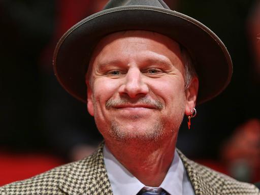 Robert Stadlober mit Hut bei der Eröffnung der Berlinale 2025 auf dem roten Teppich vor dem Berlinale-Palast.
