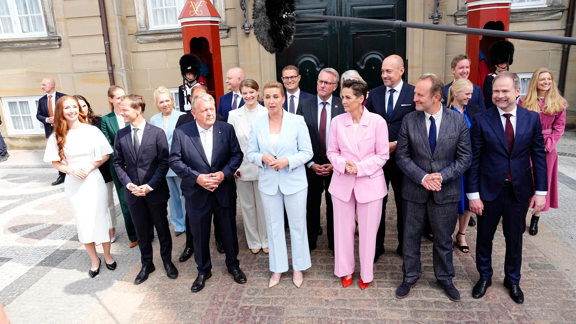 Mette Frederiksen steht mit ihren neuen Kabinettsmitgliedern zu einem Foto zusammen.