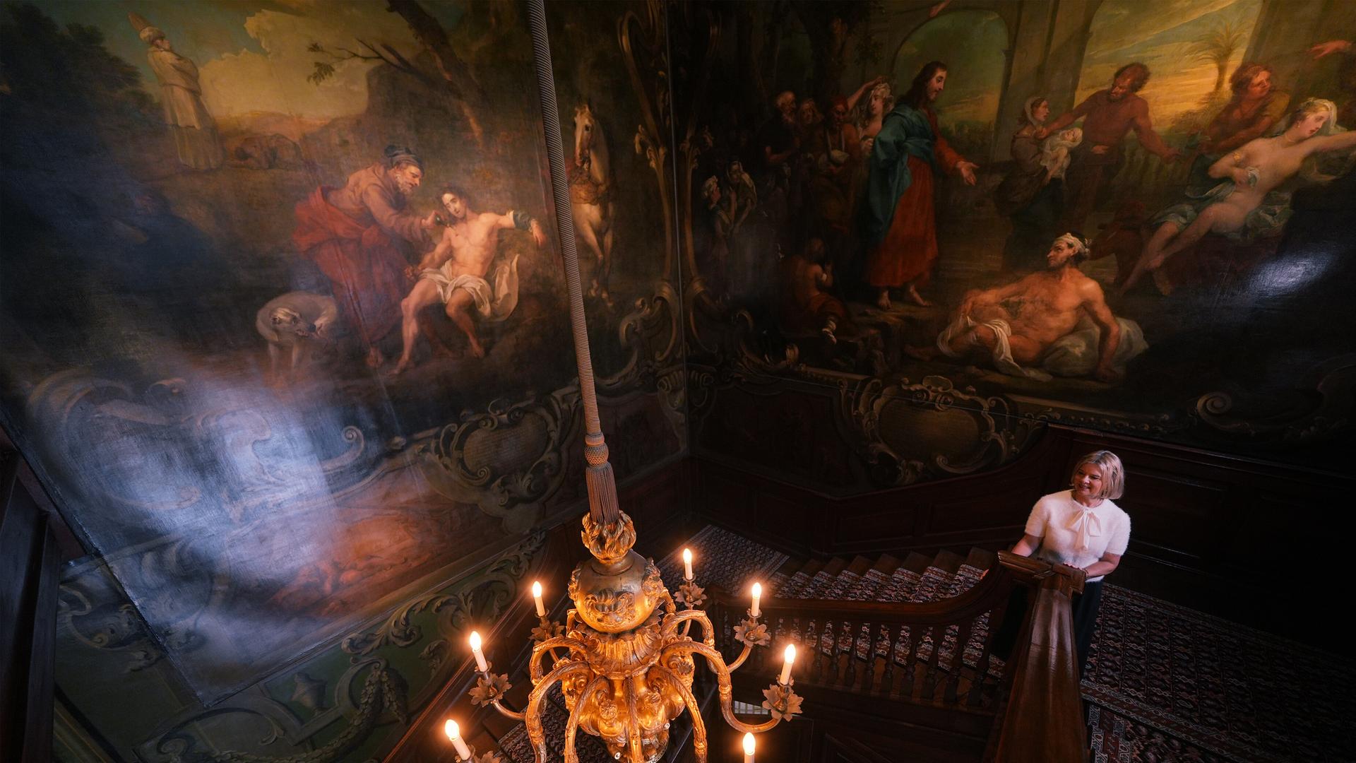 Der Nordflügel des St Bartholomew’s Hospital in West Smithfield im Zentrum Londons, in dem eine Krankenschwester in der großen Treppenhalle steht, die mit Historiengemälden von William Hogarth geschmückt ist.