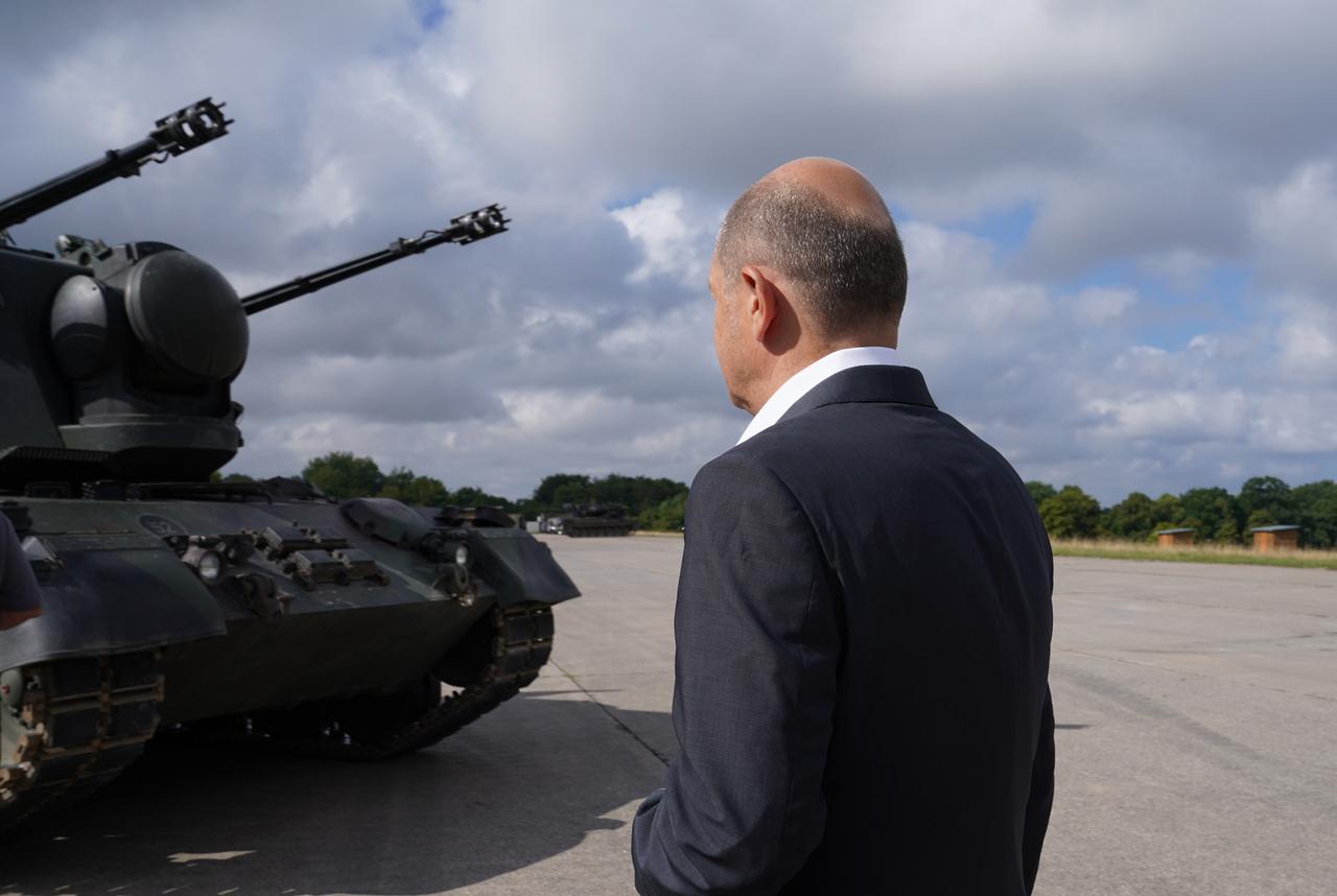 Bundeskanzler Olaf Scholz (SPD) besucht das Ausbildungsprogramm für ukrainische Soldaten an dem Flugabwehrkanonenpanzer Gepard und steht vor einem Gepard Panzer