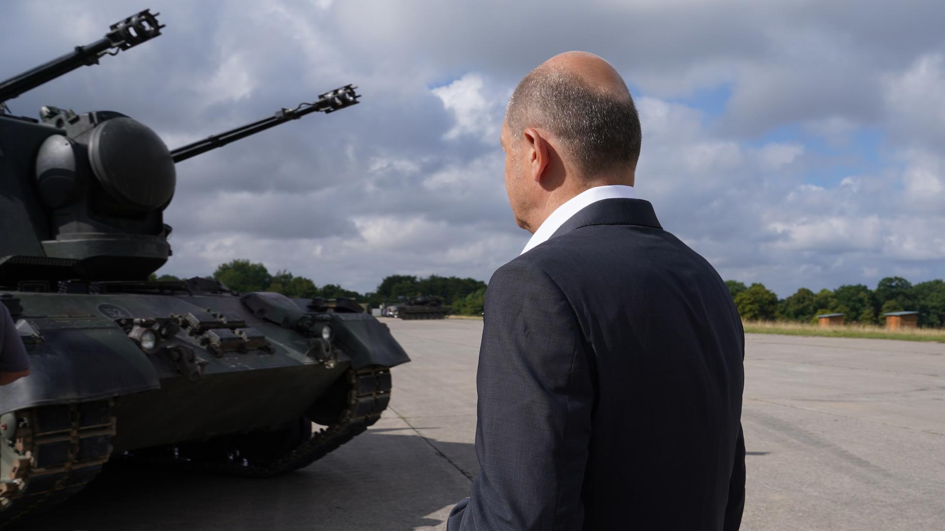 Bundeskanzler Olaf Scholz (SPD) besucht das Ausbildungsprogramm für ukrainische Soldaten an dem Flugabwehrkanonenpanzer Gepard und steht vor einem Gepard Panzer