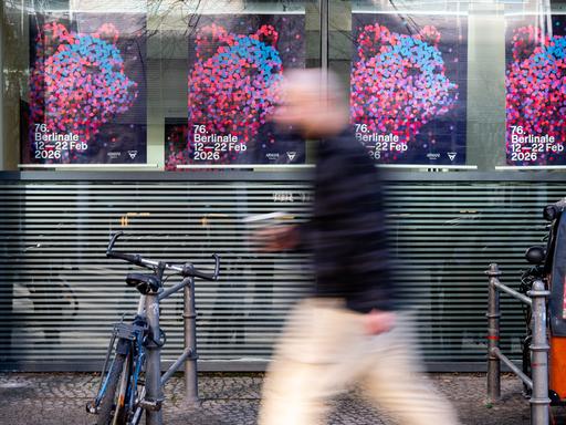 Ein Mann geht nahe des Potsdamer Platzes an Plakaten der Berlinale vorbei. Nach dem Festival gibt es eine Diskussion über die zukünftige Leitung der Berlinale.