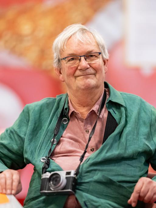 Der britische Magnum-Fotograf Martin Parr sitzt in der Ausstellung "Grand Hotel Parr" - Fotobücher von Martin Parr, im Neuen Museum Nürnberg (NMN) im "Dining Room". 