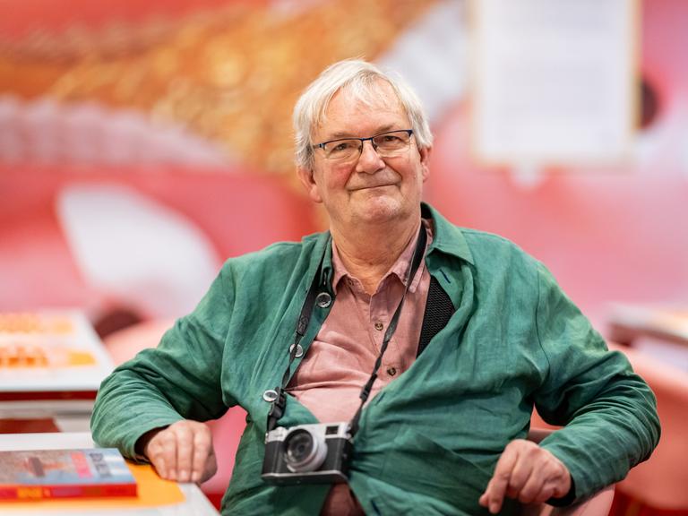 Der britische Magnum-Fotograf Martin Parr sitzt in der Ausstellung "Grand Hotel Parr" - Fotobücher von Martin Parr, im Neuen Museum Nürnberg (NMN) im "Dining Room". 