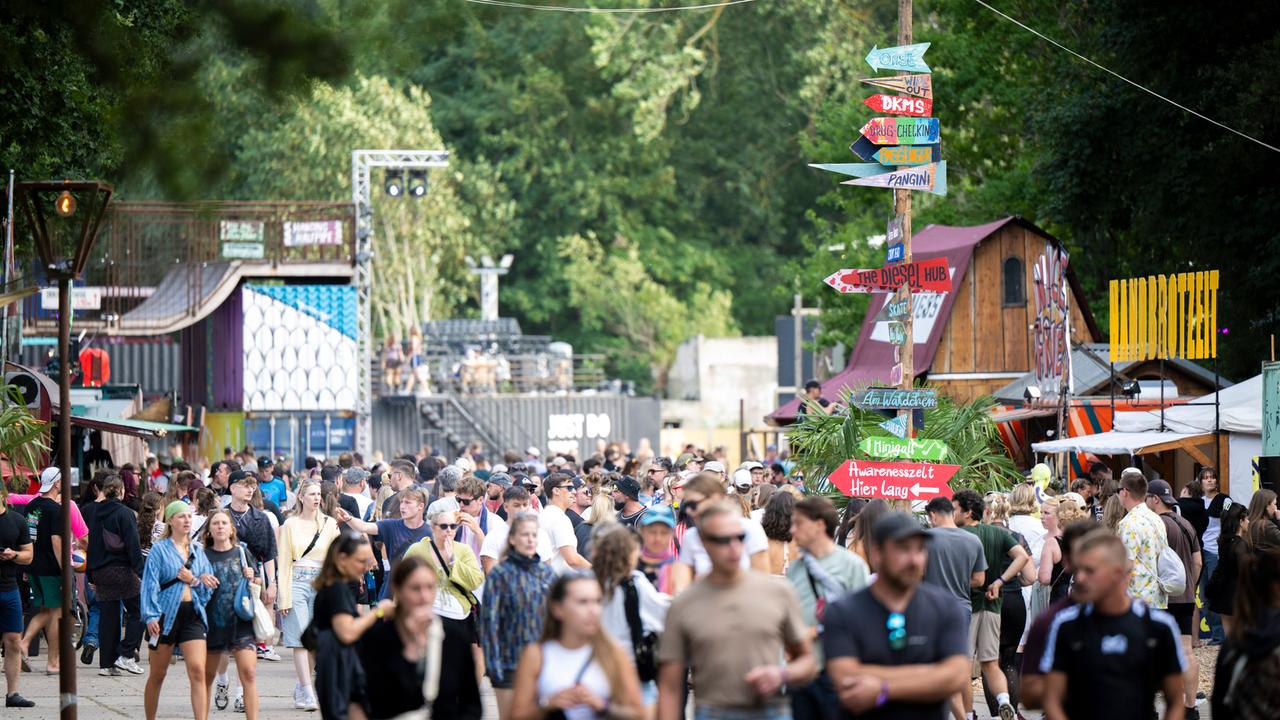 Zahlreiche Festivalbesucher laufen über ein Veranstaltungsgelände.