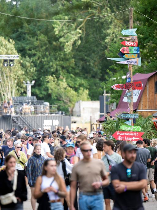 Zahlreiche Festivalbesucher laufen über ein Veranstaltungsgelände.