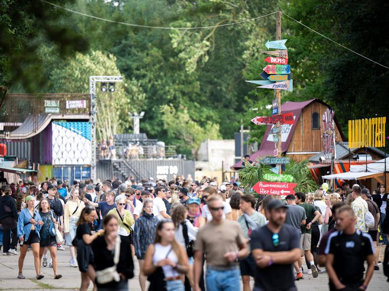 Zahlreiche Festivalbesucher laufen über ein Veranstaltungsgelände.