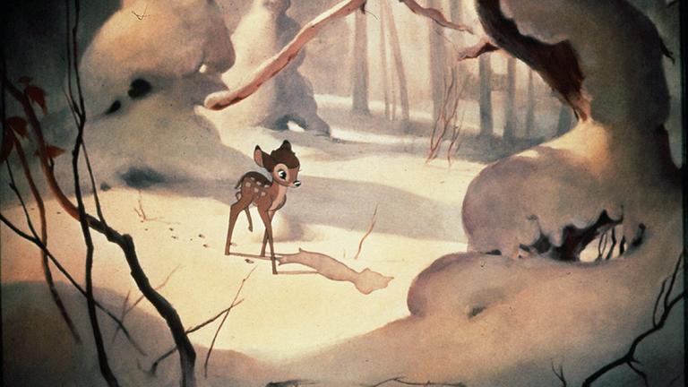 Filmstill bei dem Bambi, das Rehkiz, alleine im verschneiten Wald steht