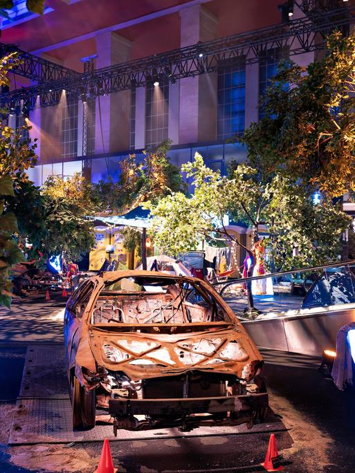 Einblick in die Nova-Festival-Ausstellung in Berlin: In gedämpfter Lichtstimmung ist ein ausgebranntes Auto zu sehen