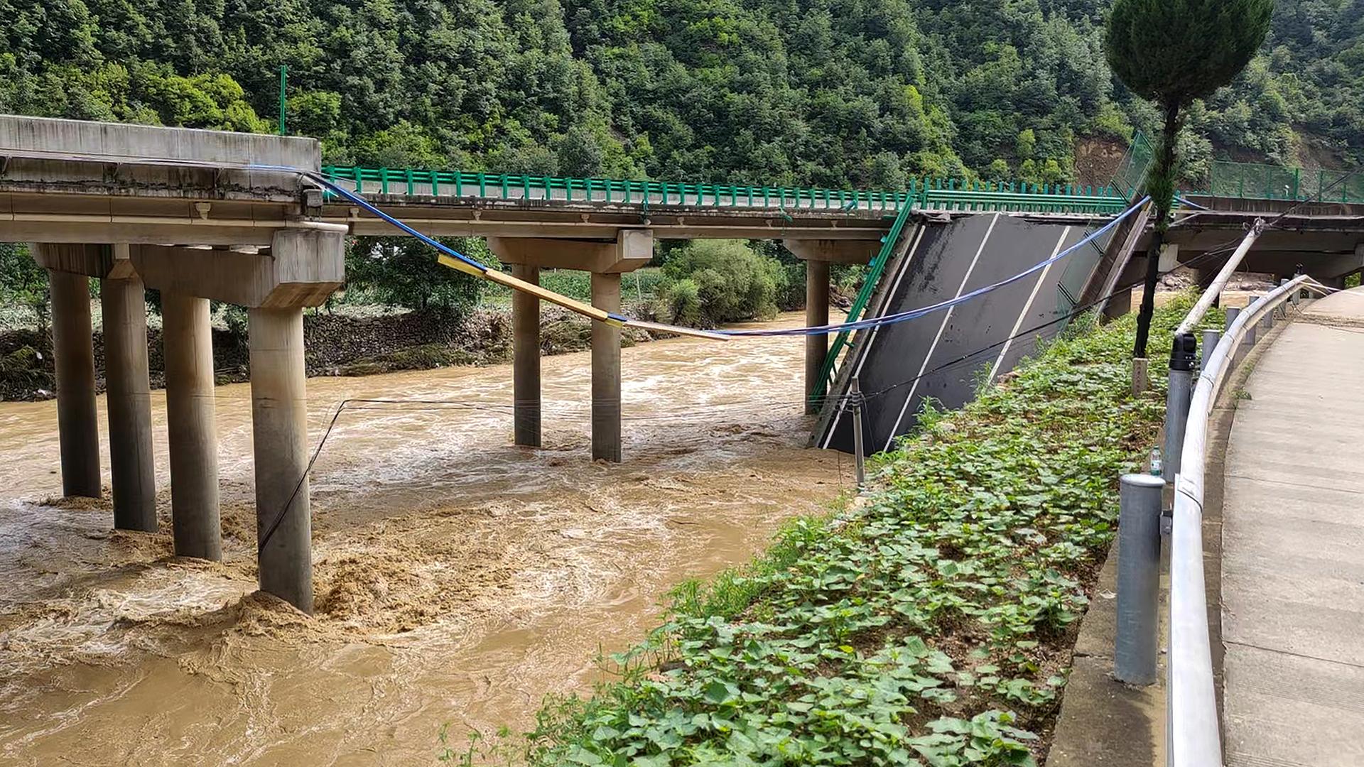 Eine teilweise eingestürzte Brücke über einem Fluss.