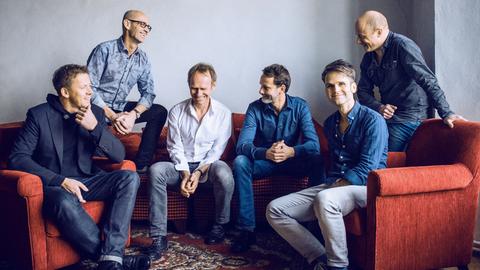 Die Band Keimzeit sitzt lachend auf einem Sofa
