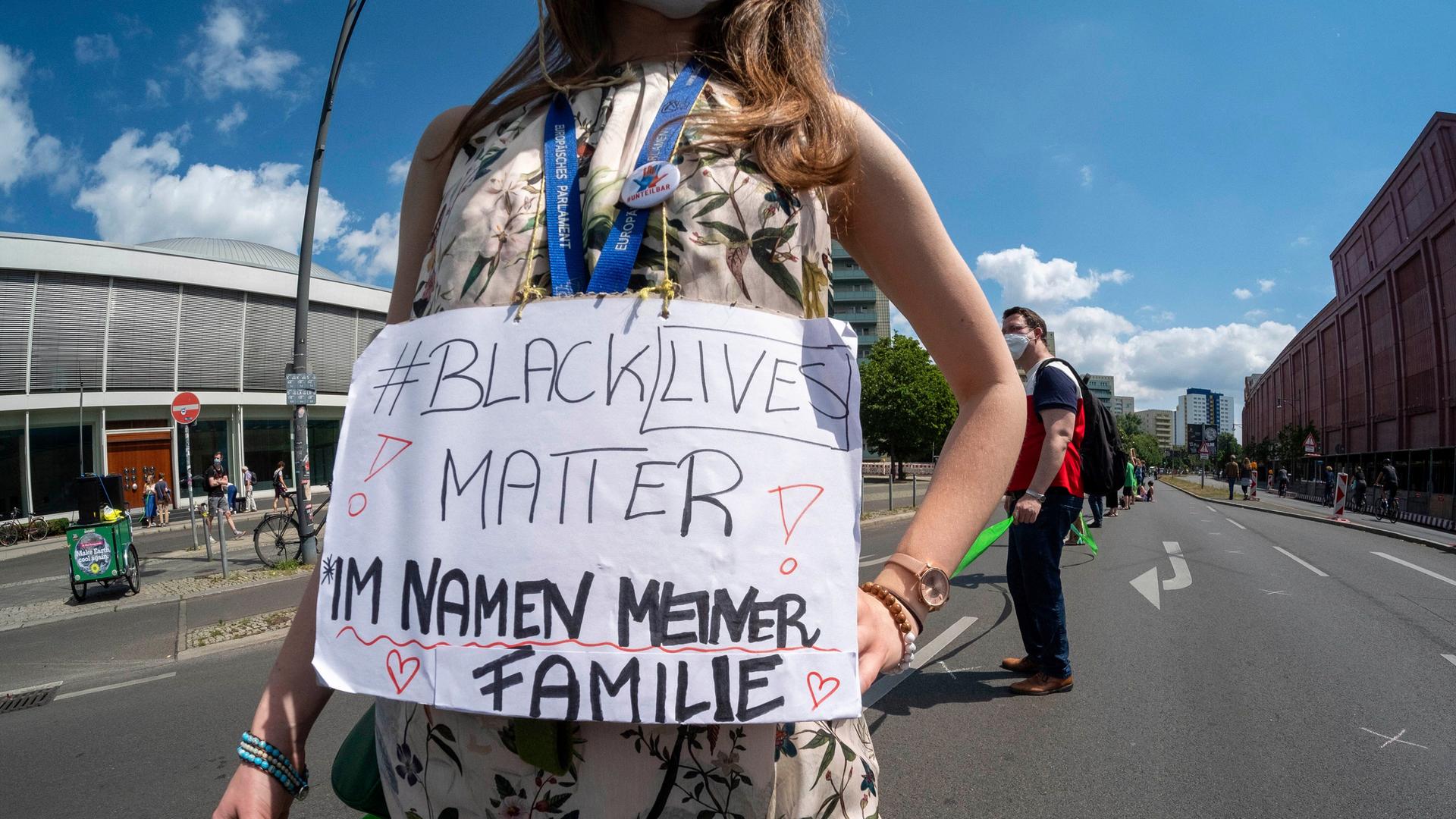 Eine Menschenkette gegen Rassismus und soziale Ungerechtigkeit vom Brandenburger Tor in Berlin-Mitte bis zum Hermannplatz in Berlin-Neukölln. Eine Frau trägt einen Banner um ihren Bauch mit der Aufschrift "Black live matter - Im Namen meiner Familie".