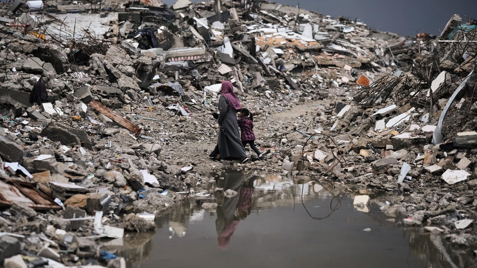 Stadt Gaza: Palästinenser gehen bei stürmischem Wetter durch die Trümmer in Gaza.