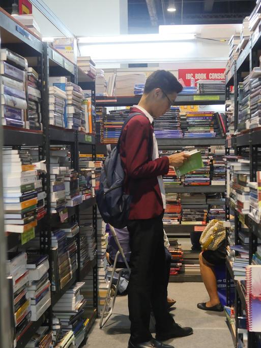 Ein Mann liest in einer Buchhandlung ein Buch - auf der 37. Internationalen Buchmesse in Manila